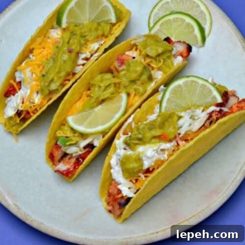 Three bbq pork chop tacos with guacamole.