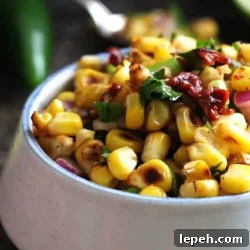 A bowl of salsa made of chipotle pepper and corn.