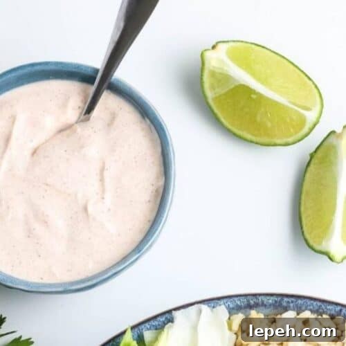 A bowl of homemade dressing with limes near.