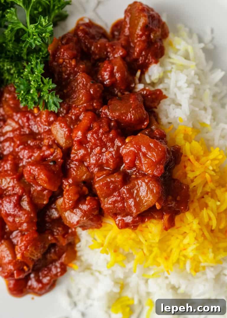 closeup: serving of eggplant stew over steamed white and yellow rice