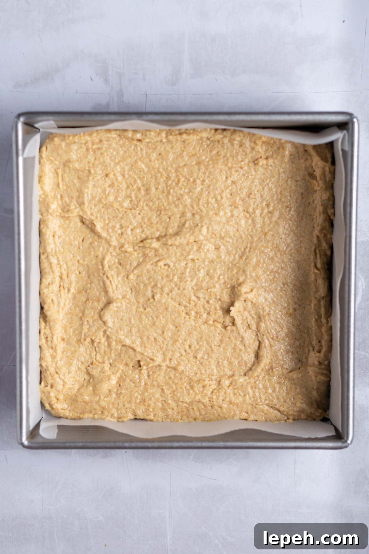 cake batter in a parchment lined baking tin