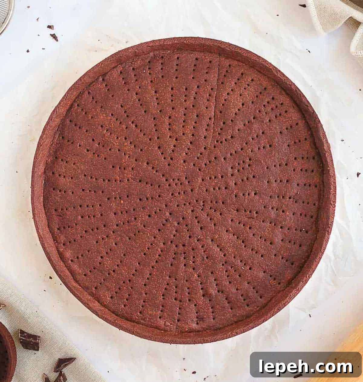Baked pie crust seen from above on a white surface.