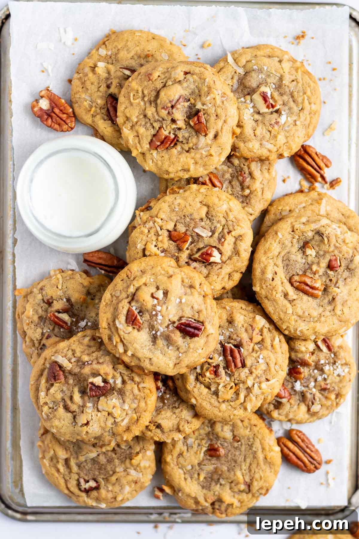 pile of coconut pecan cookies with a glass of milk