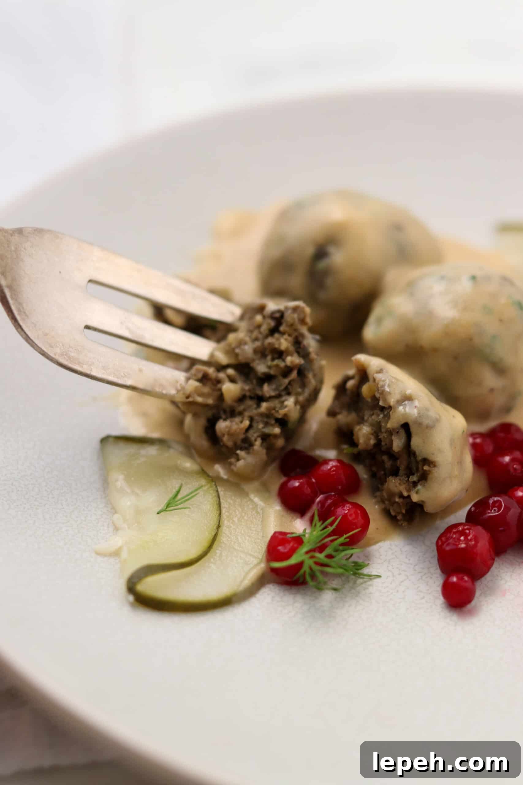 Close up of Vegetarian Swedish Meatballs with pickles and lingonberries.