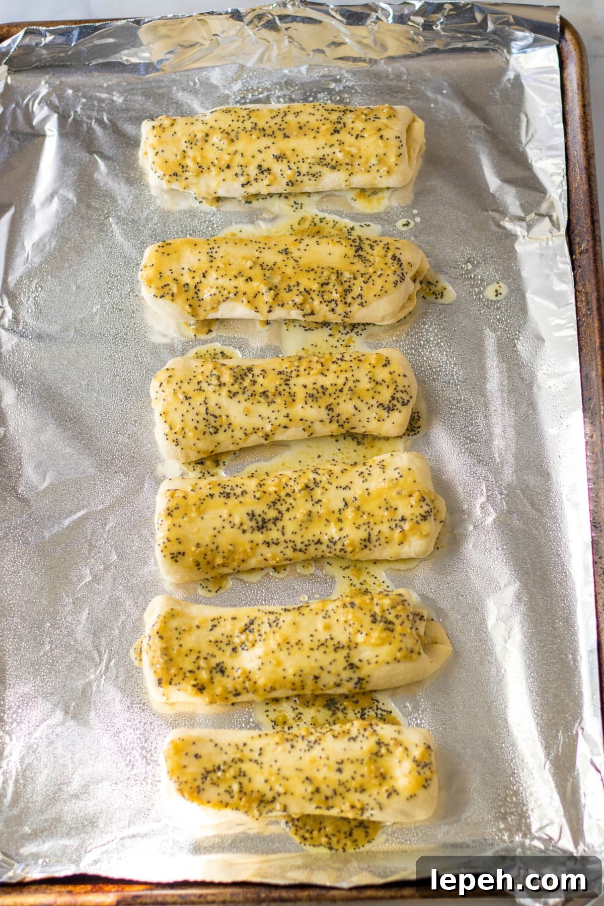 Brushing the butter mixture on top.