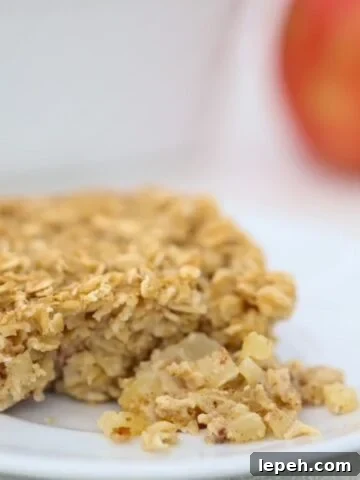 One piece of Baked Oatmeal with Apples and Cinnamon on a white plate.