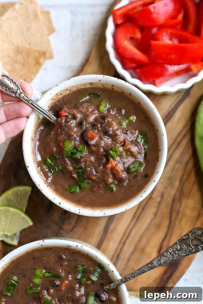 black bean soup in a bowl with a spoon taking a bite 