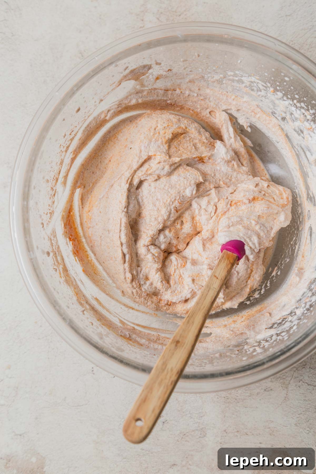 pumpkin whipped cream in a bowl with a spatula.
