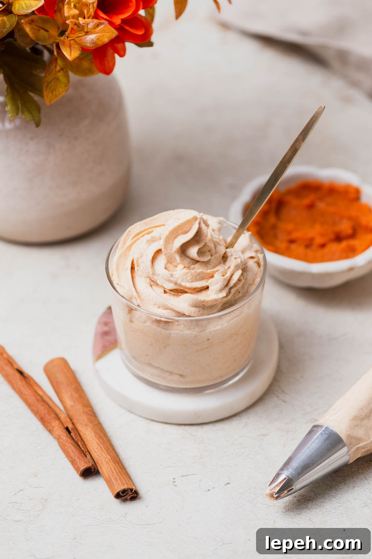 pumpkin spice whipped cream with cinnamon sticks and pumpkin puree on the side.