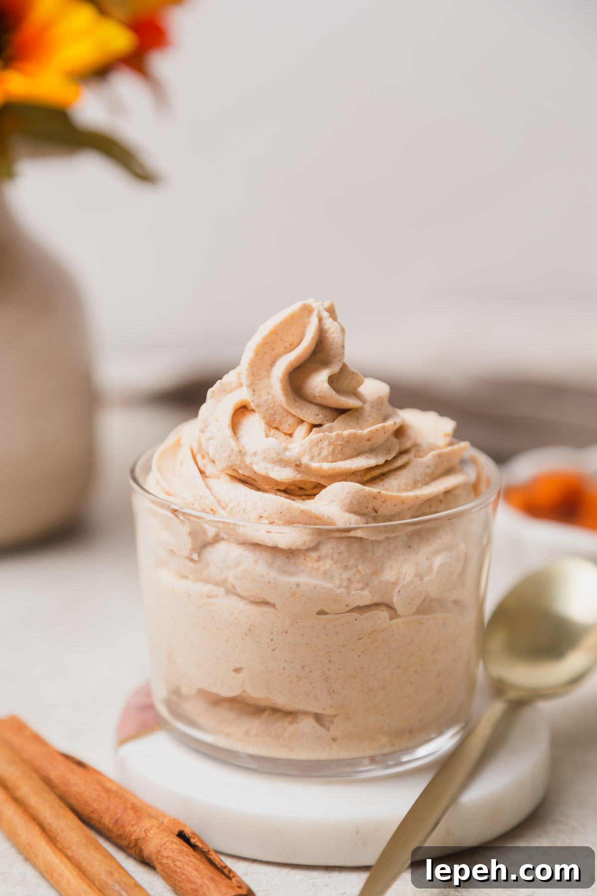 pumpkin spice whipped cream topping in a jar with a spoon.