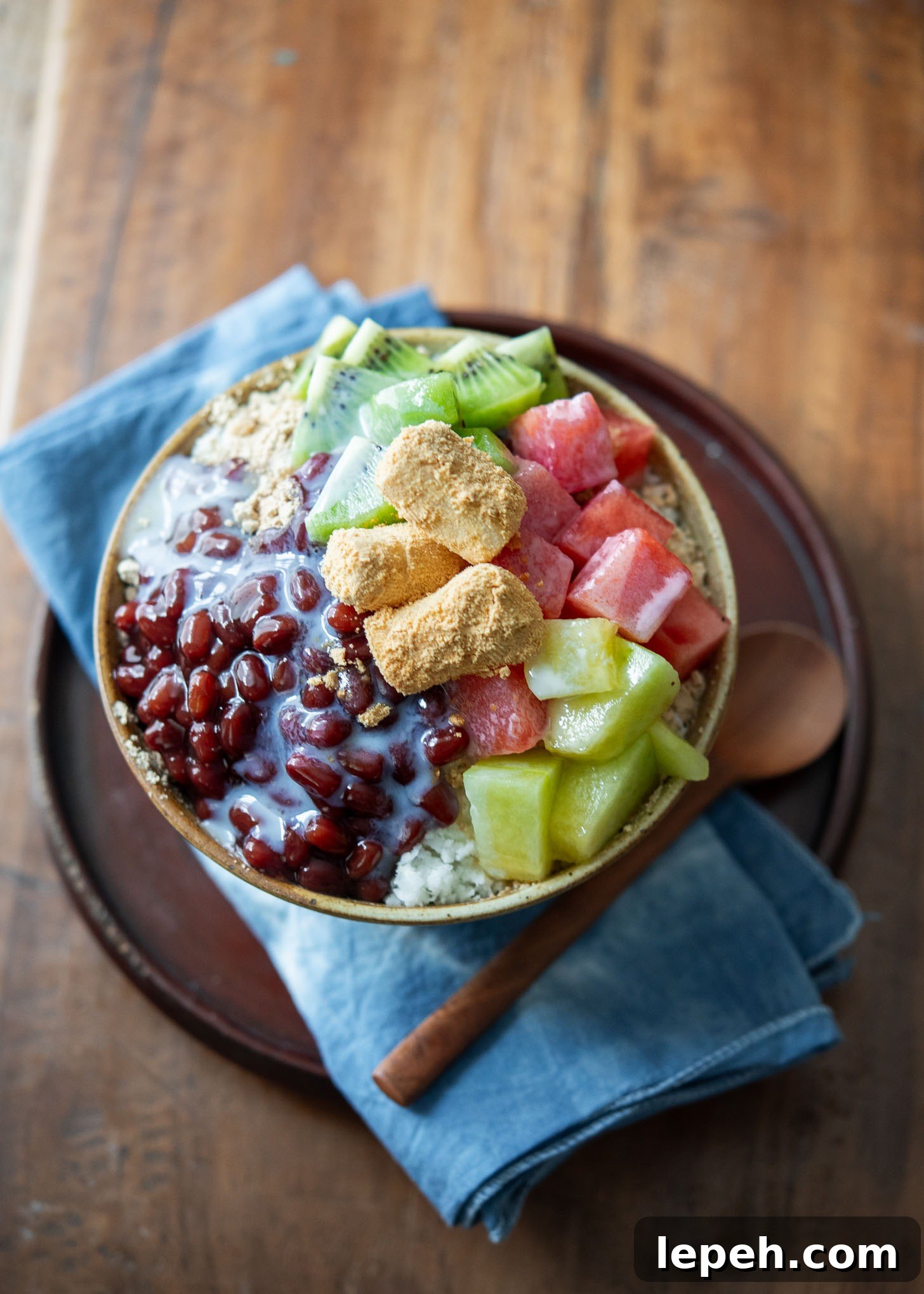 A bowl of Korean shaved ice with red beans and fruits.