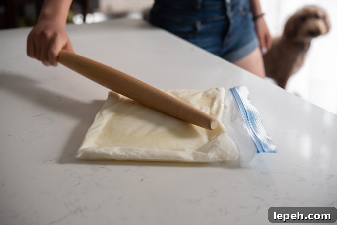 A wooden pin smacking frozen milk in a zip bag.