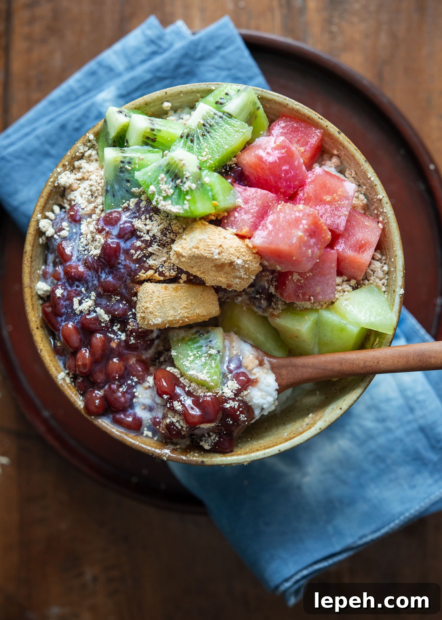 Korean shaved milky ice with red beans and fruits in a bowl.