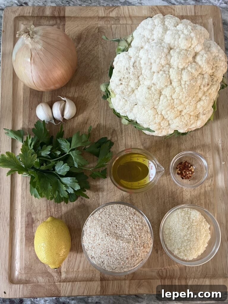 All ingredients for smashed sauteed cauliflower on cutting board.