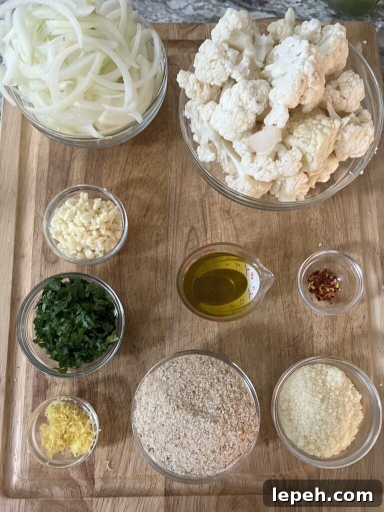 All prepped ingredients for italian sautéed cauliflower in glass bowls on cutting board.