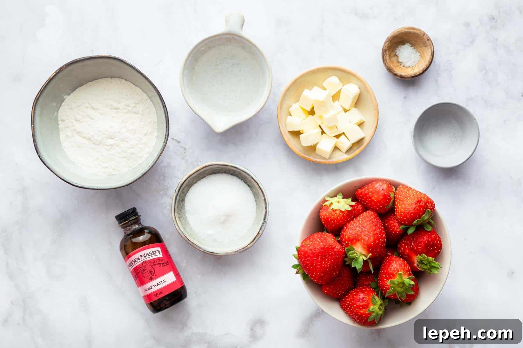 Small bowls of flour, sugar, diced butter, and whole strawberries.