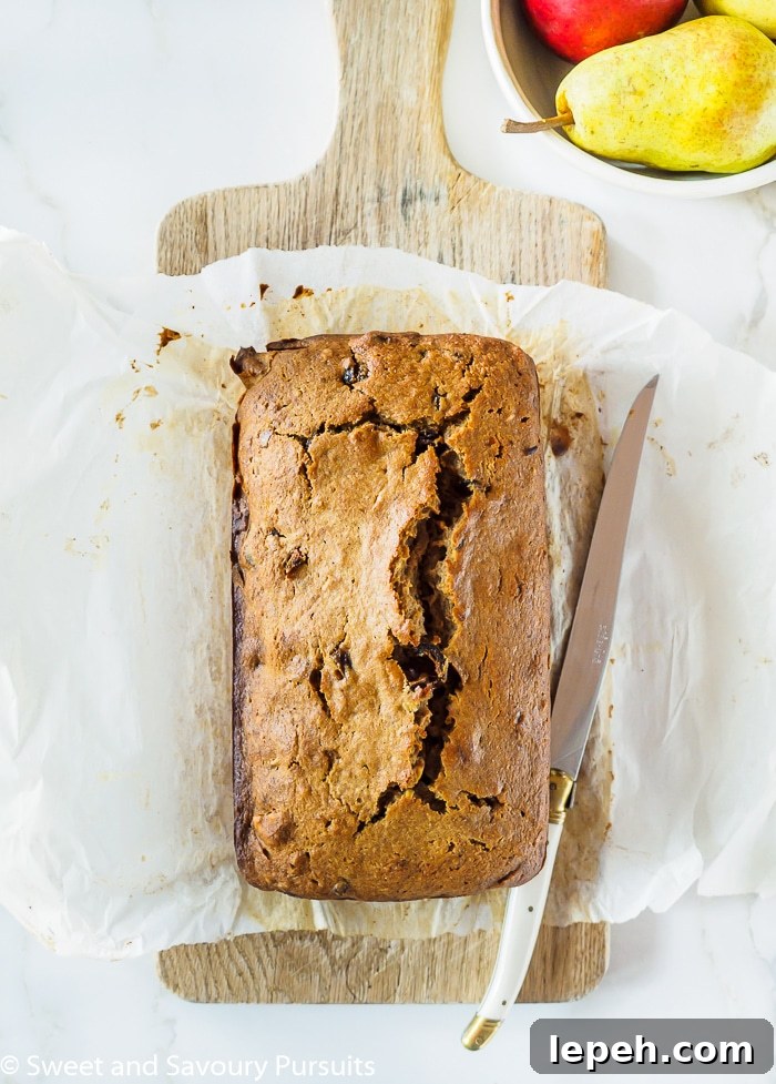 Top view of Pear, Date and Walnut Loaf on wooden cutting board.