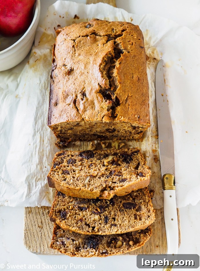 Sliced Pear, Date and Walnut Loaf cake on cutting board.