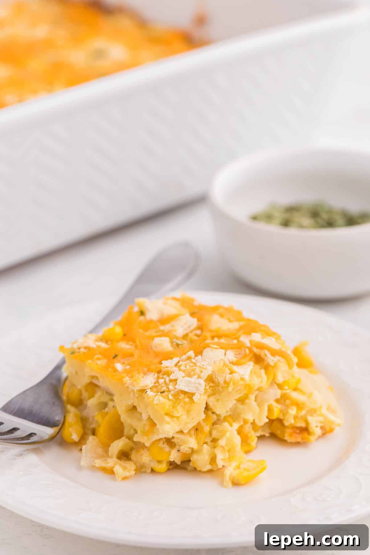 A piece of casserole on a plate with a fork.