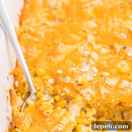 The recipe in a white casserole dish with a serving spoon.