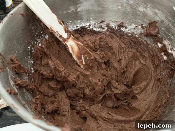 Rich chocolate frosting in a mixing bowl.