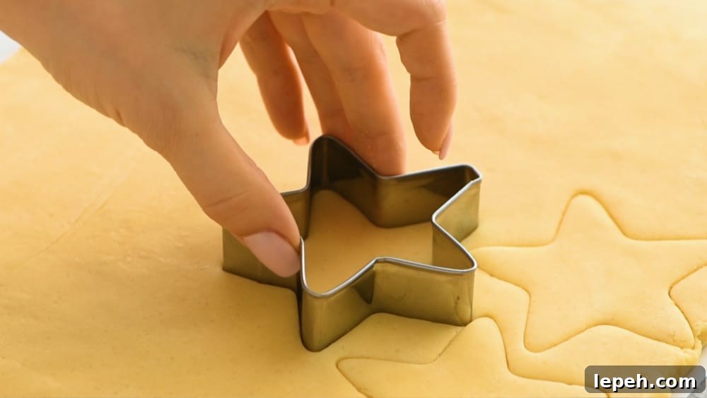 Cutting out a star from sugar cookie dough.