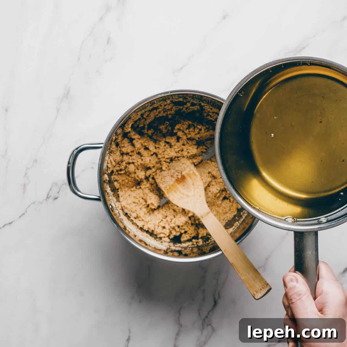 adding a sugar syrup to a pot filled with toasted semolina.