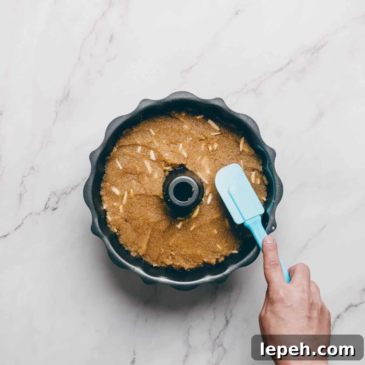 smoothing out Greek halva in a bundt pan.