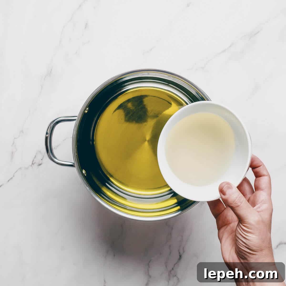 adding oil to a pot.