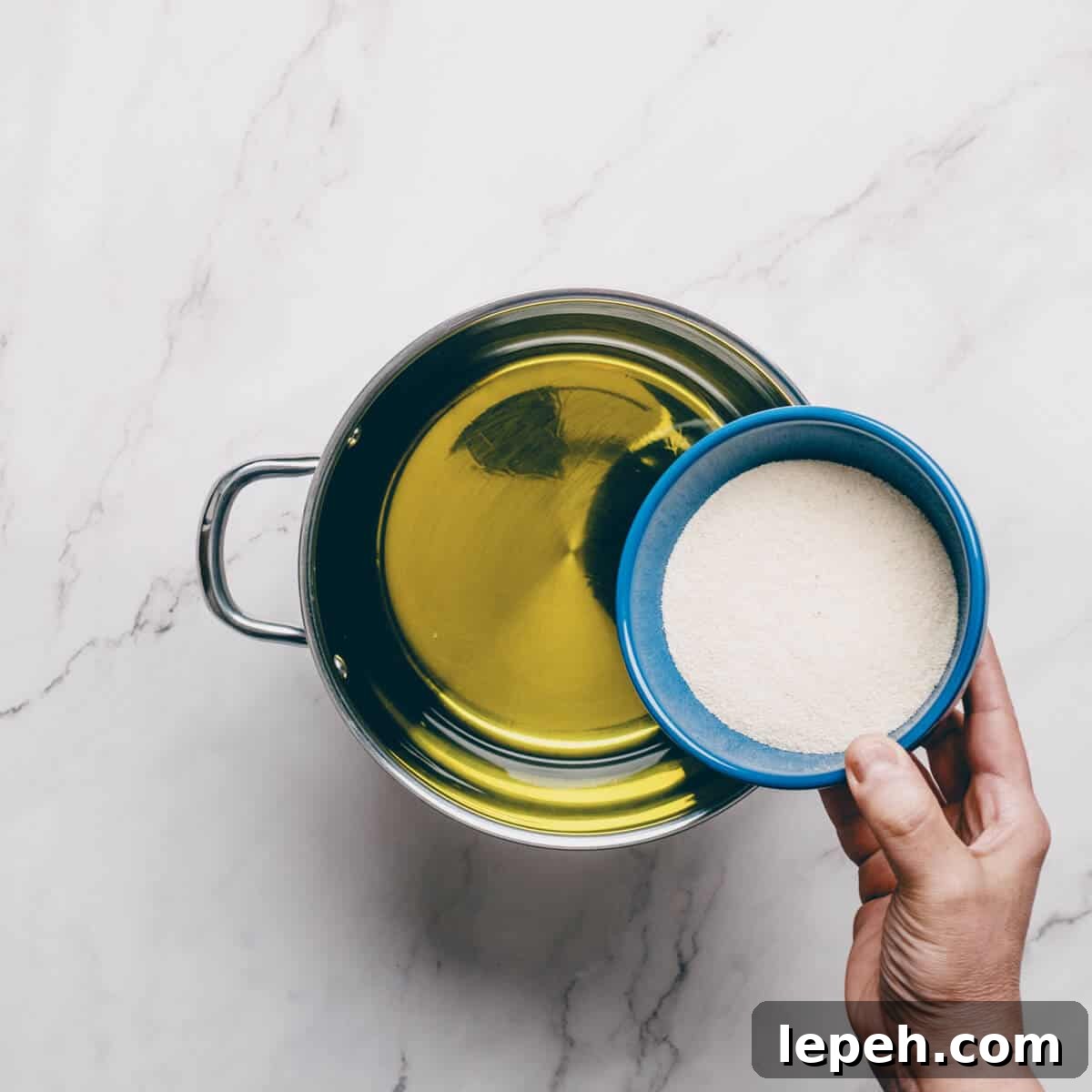 adding semolina to a pot with olive oil.