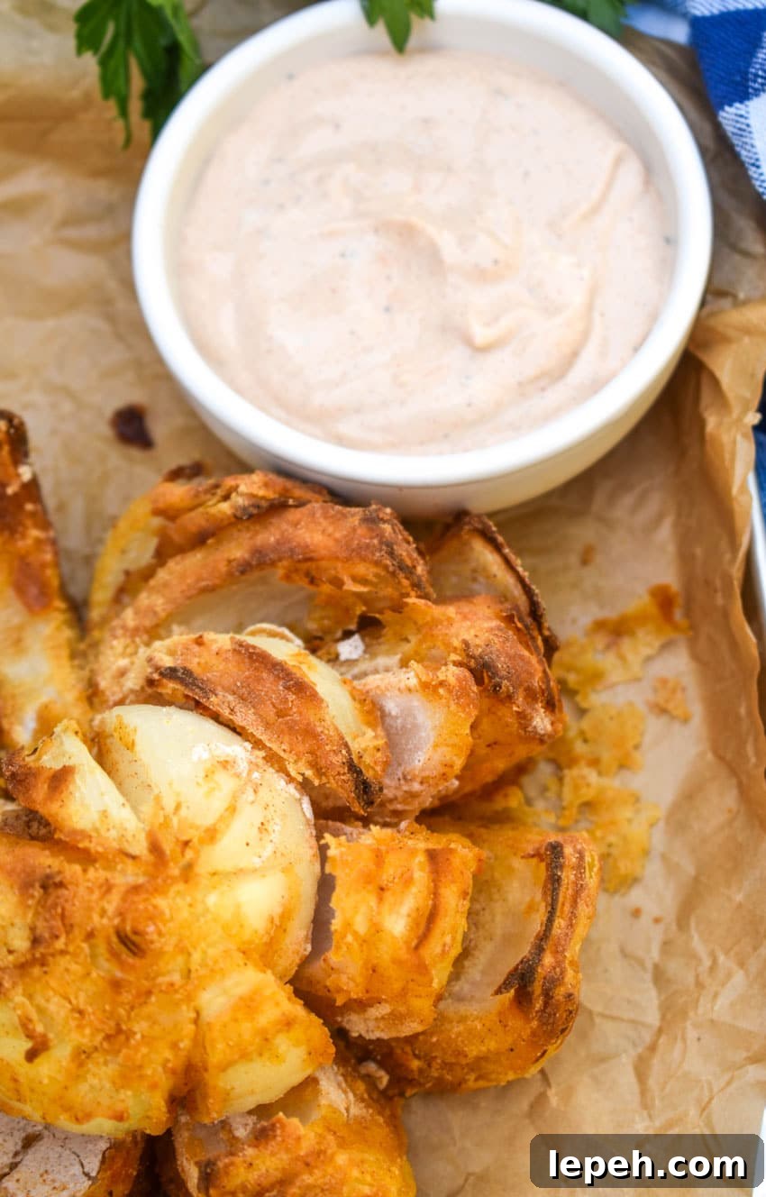 air fryer bloomin' onion on a brown parchment paper lined tray