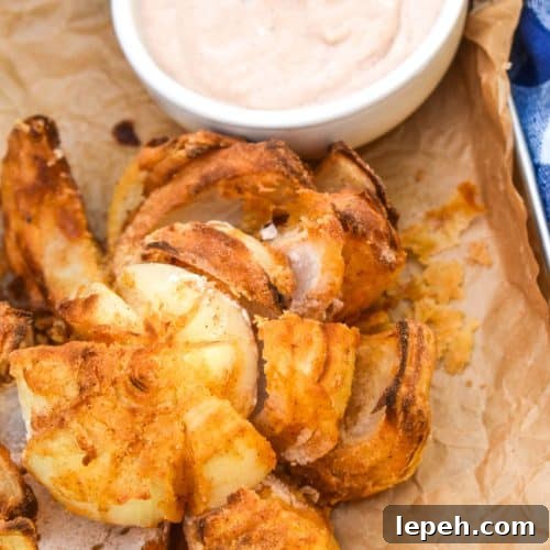 air fryer bloomin' onion on a brown parchment paper lined tray