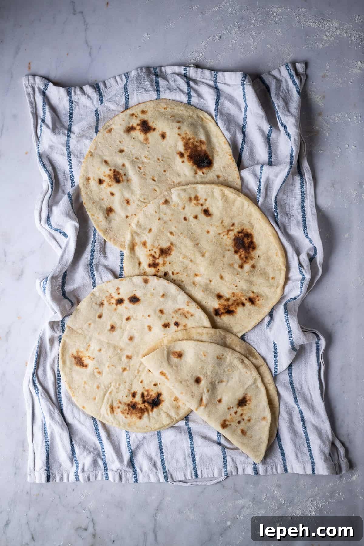 Vegan flatbreads on a tea towel on a marble backdrop