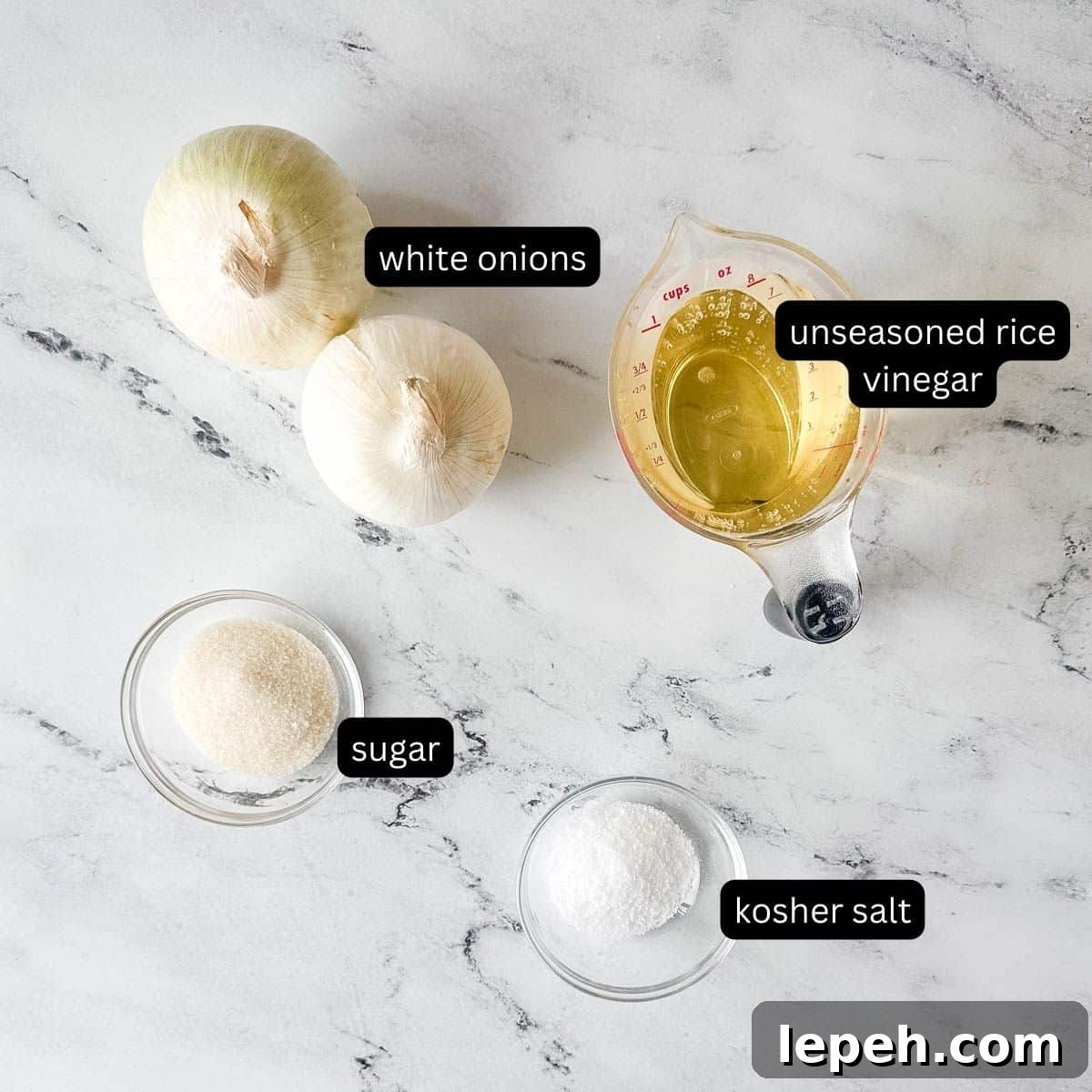 Labeled ingredients for pickled white onions on a white marble counter.