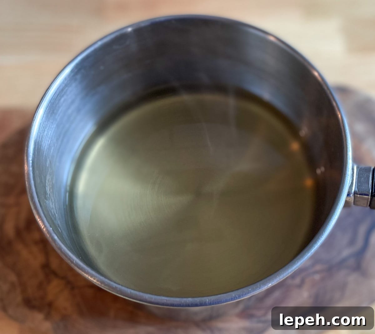 Pickling brine is warmed in a stainless steel pot.
