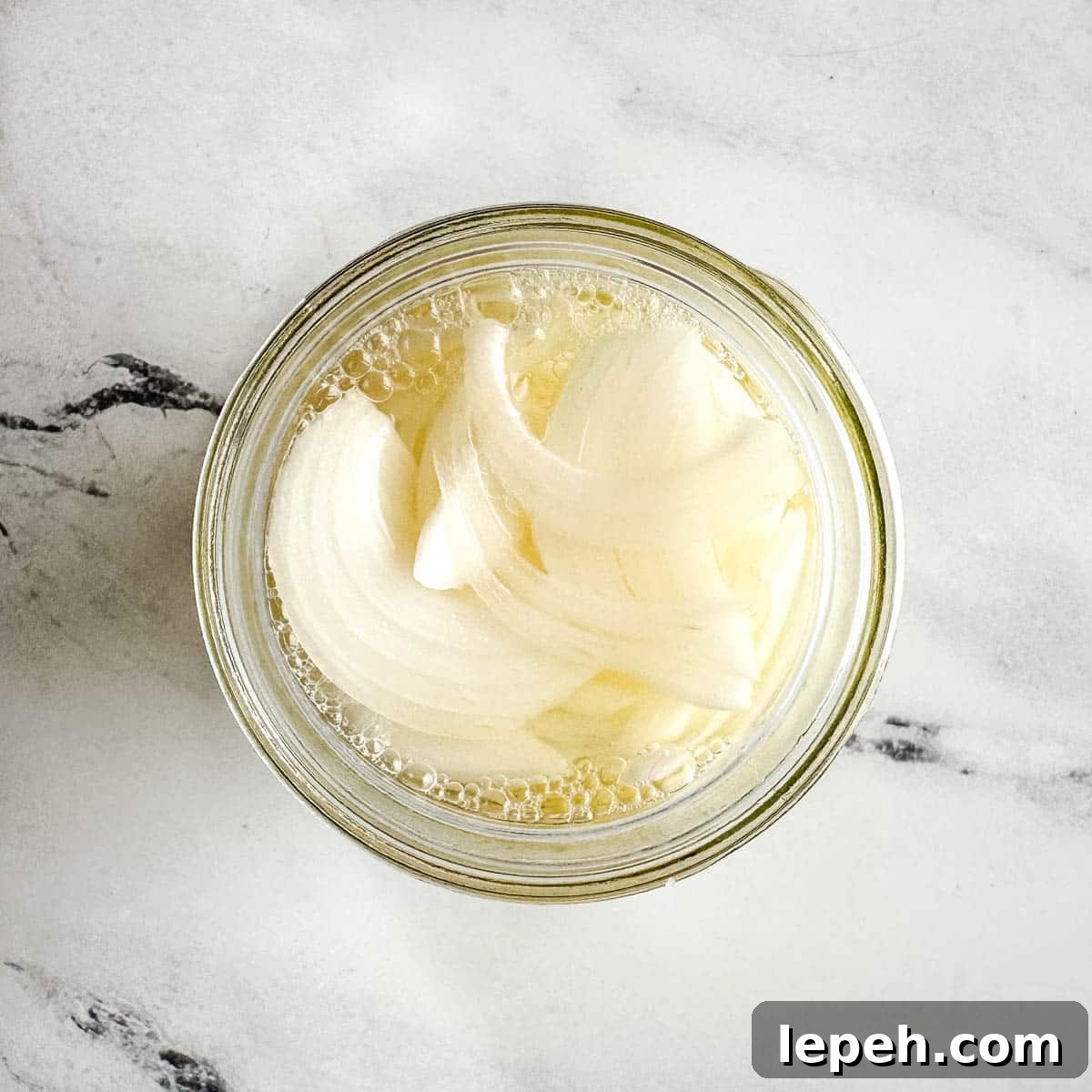 Pickled white onions in a glass jar.