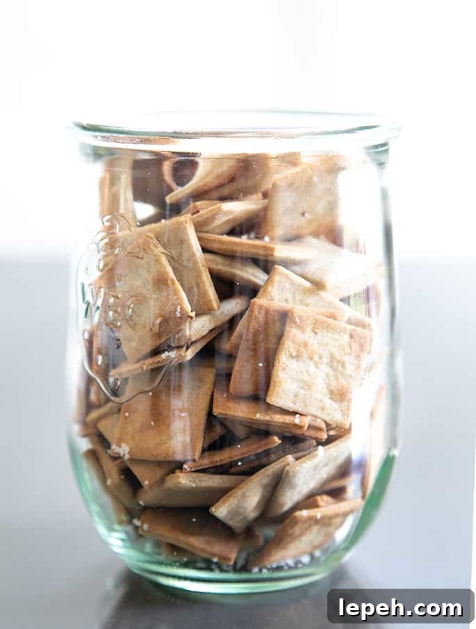 A clear glass jar with gluten free wheat thins style crackers