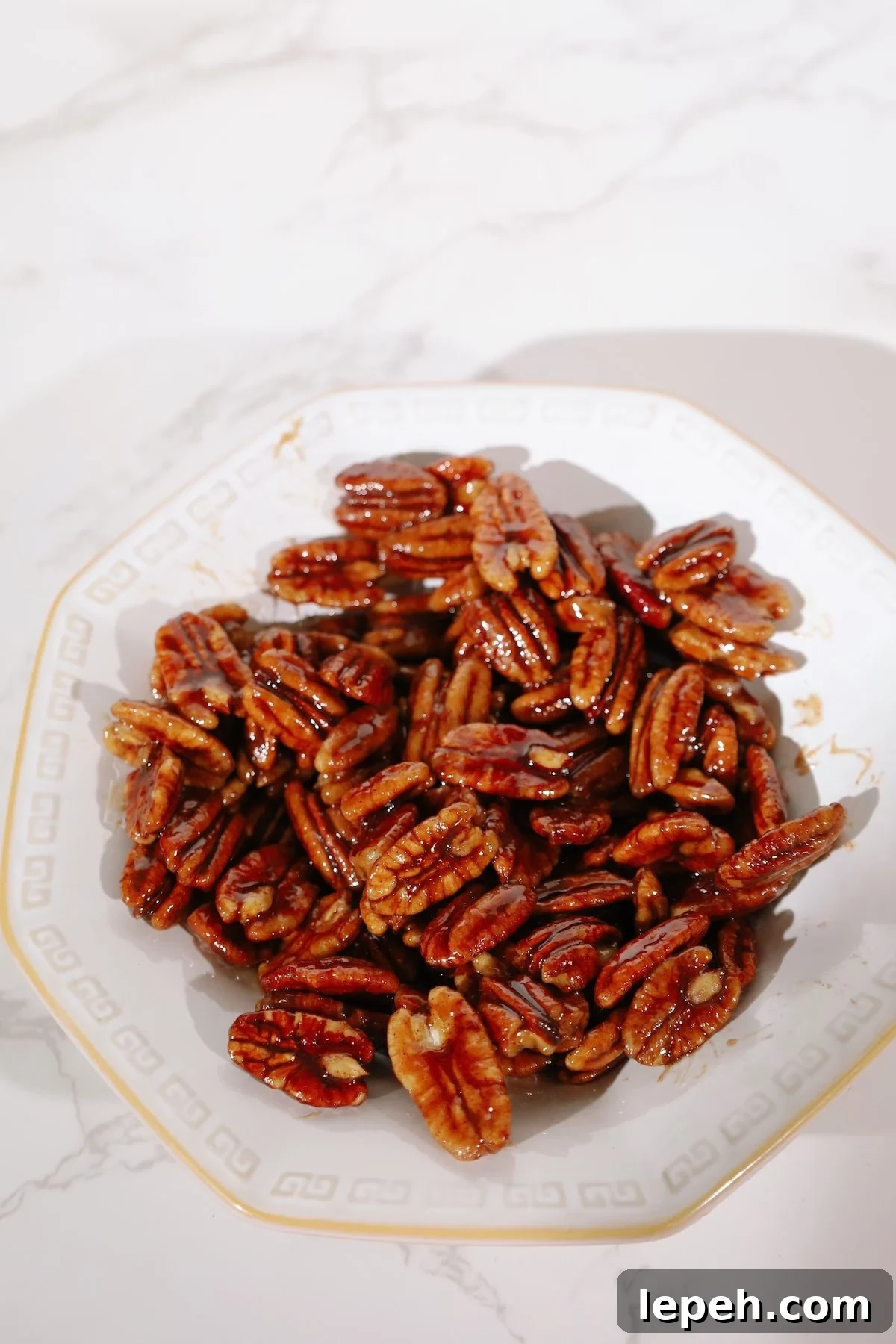 Candied pecans recipe in a white bowl.