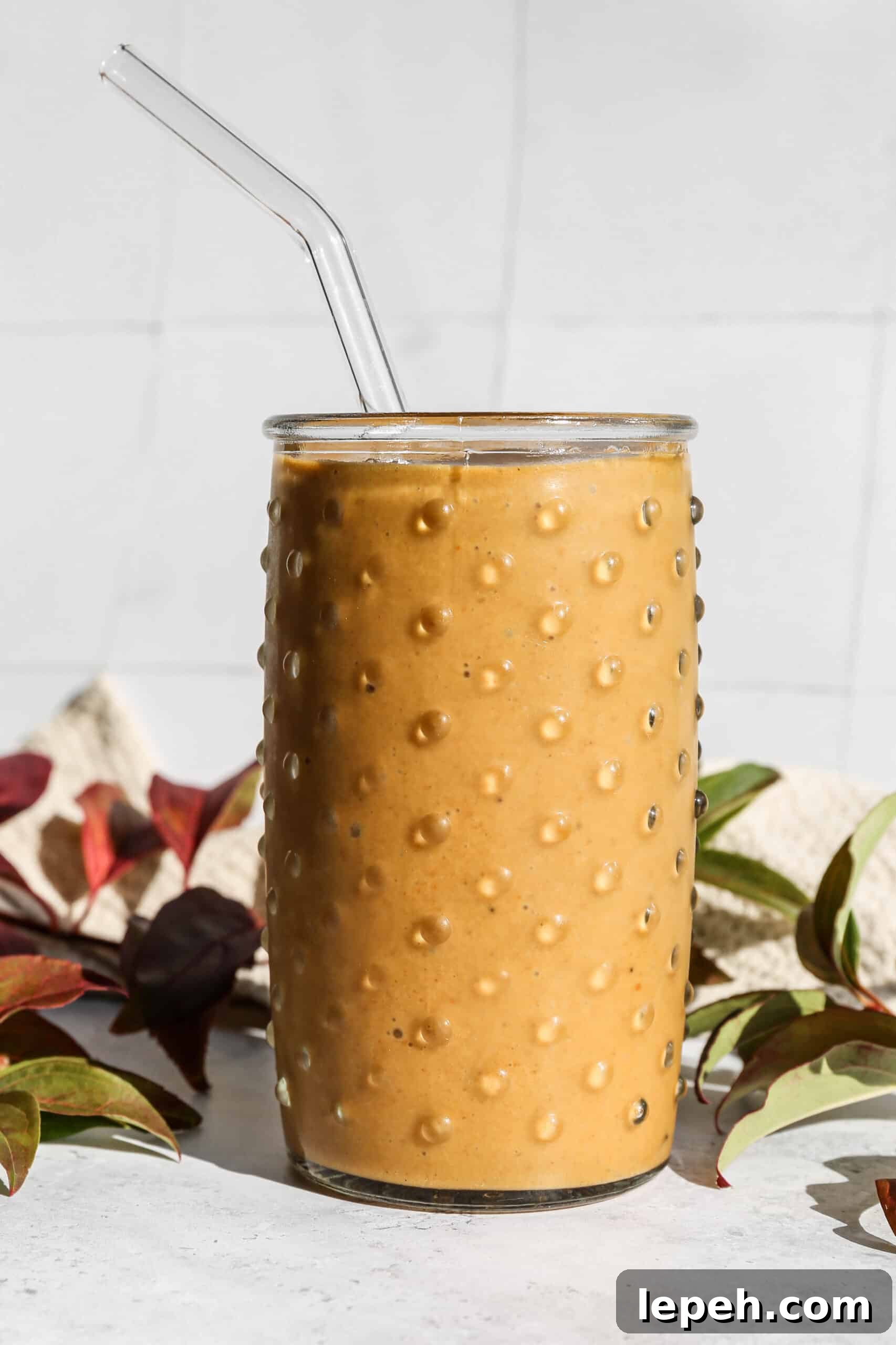 a glass of dairy free pumpkin pie smoothie made with canned pumpkin puree.