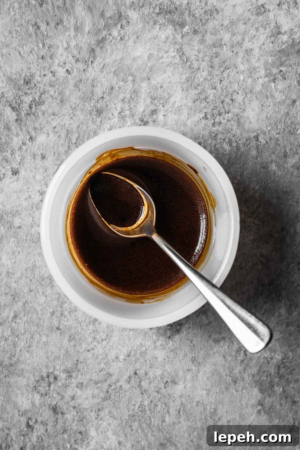 Espresso powder and vanilla extract mixed into a slurry in a small bowl.