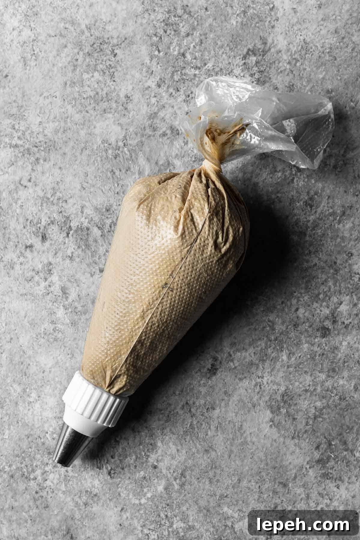 A 16 inch piping bag with a round tip filled with coffee mascarpone topping.