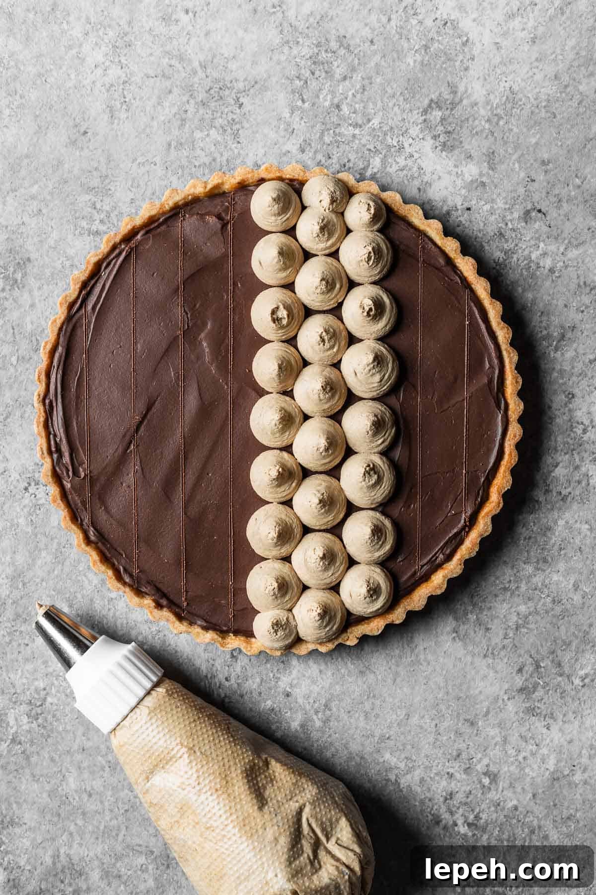 A chocolate ganache tart with guidelines marked for piping circles of coffee mascarpone topping.