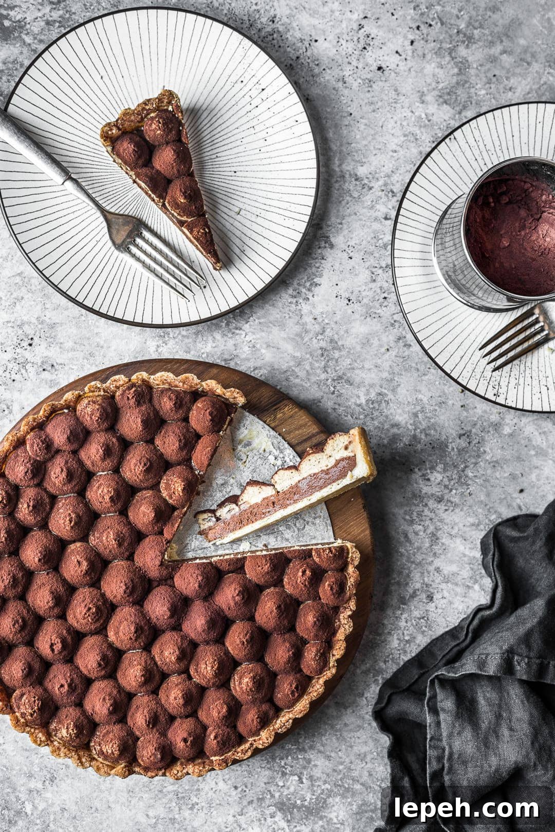 Tart with slices cut out of it with slices resting on a plate nearby