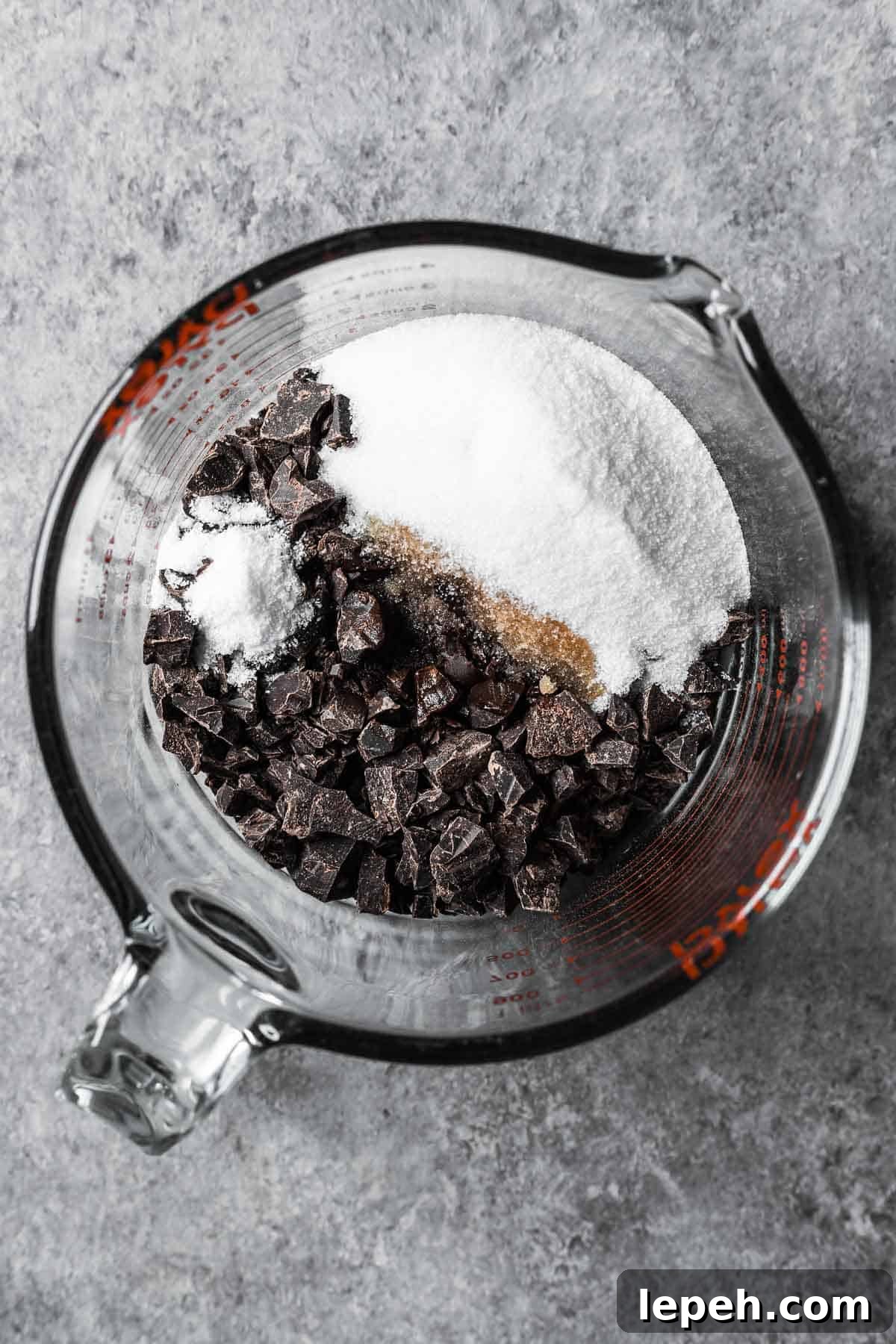 Chopped dark chocolate, sugar, vanilla and salt in a glass measuring container.