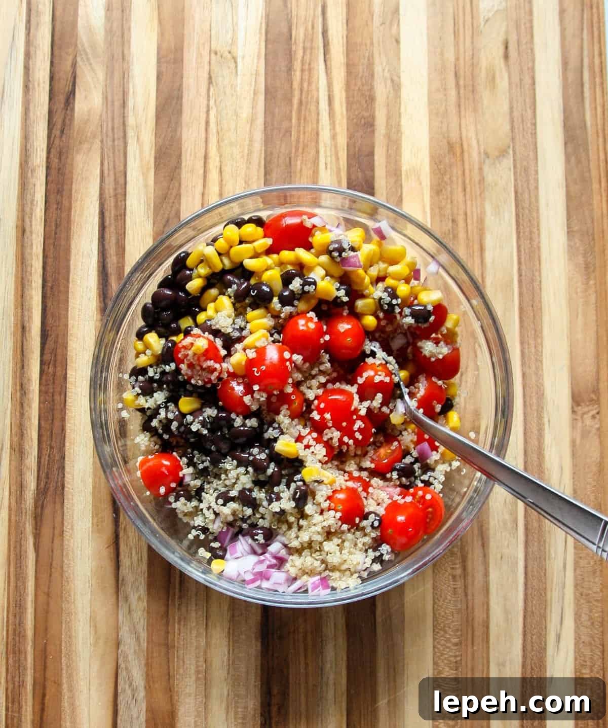 Tossing salad ingredients together in a large bowl.