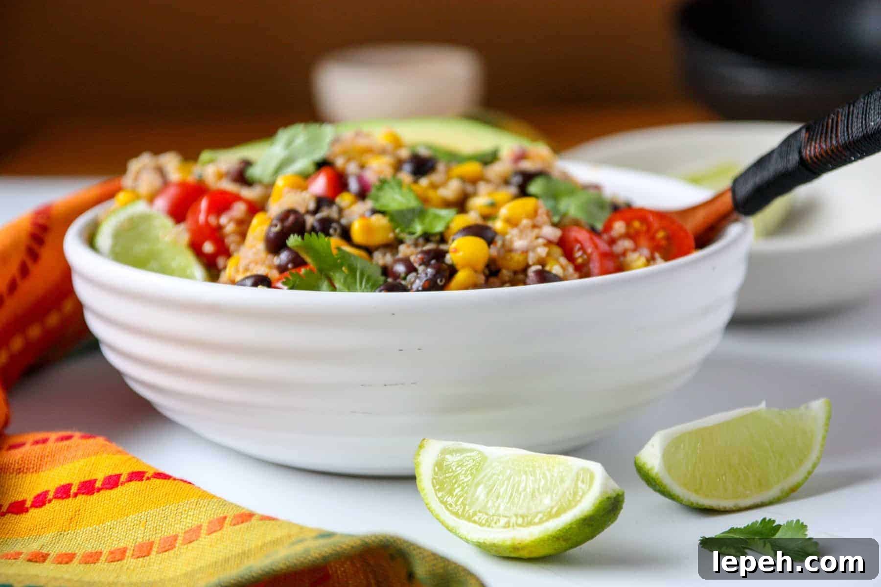 A white bowl filled with salad on a table, with lime wedges.
