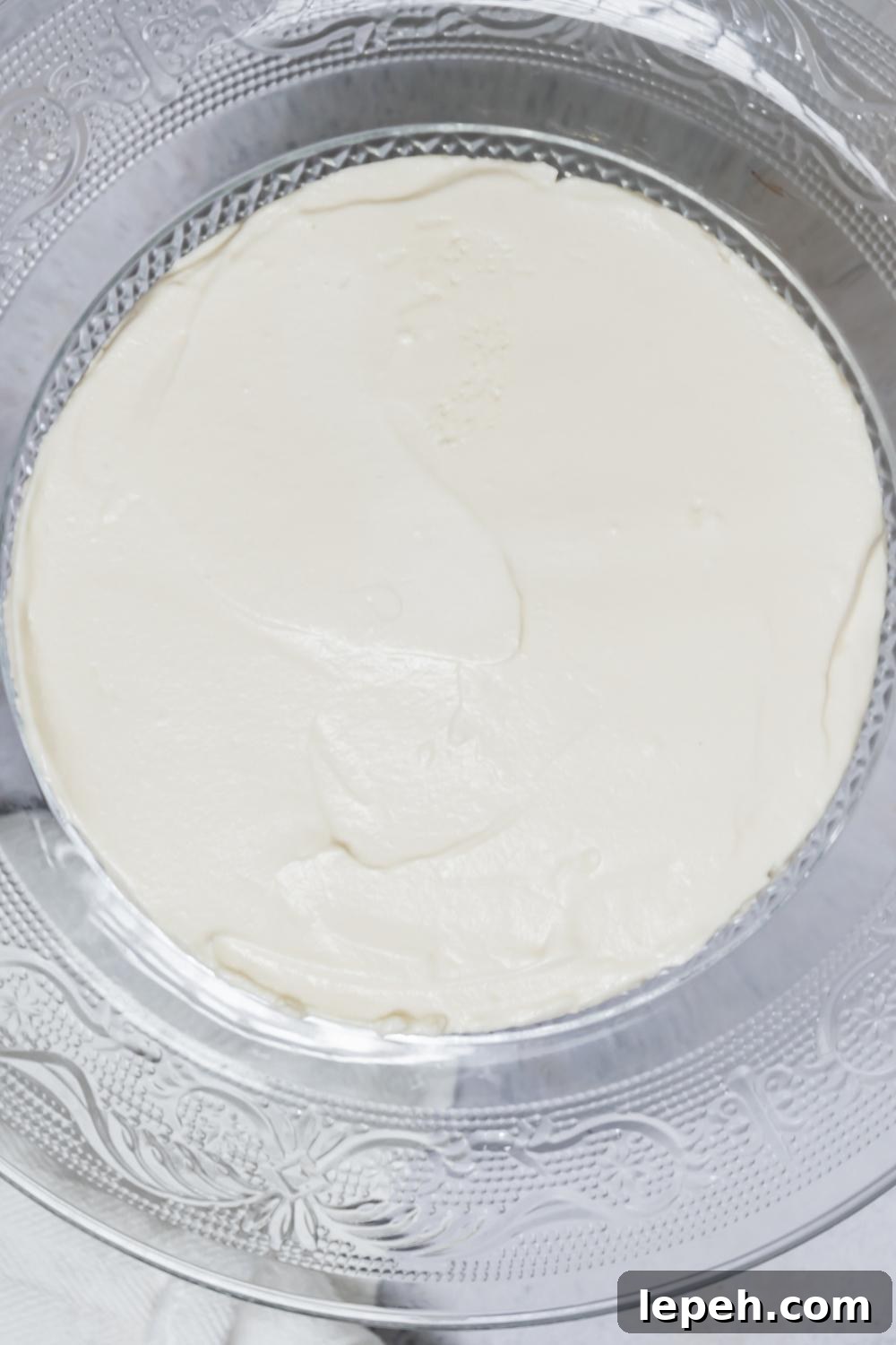An overhead view of a Philadelphia no bake cheesecake on a cake stand.