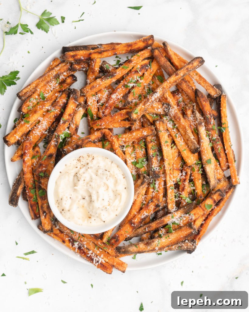 crispy oven baked yam fries are topped with finely  shredded parmesan cheese and served with a flavorful homemade truffle lemon aioli