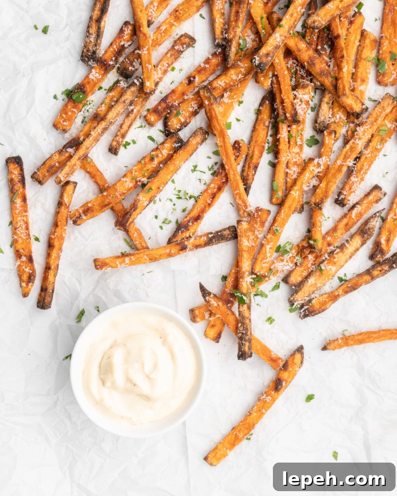 crispy oven baked yam fries are topped with finely shredded parmesan cheese and served with a flavorful homemade truffle lemon aioli