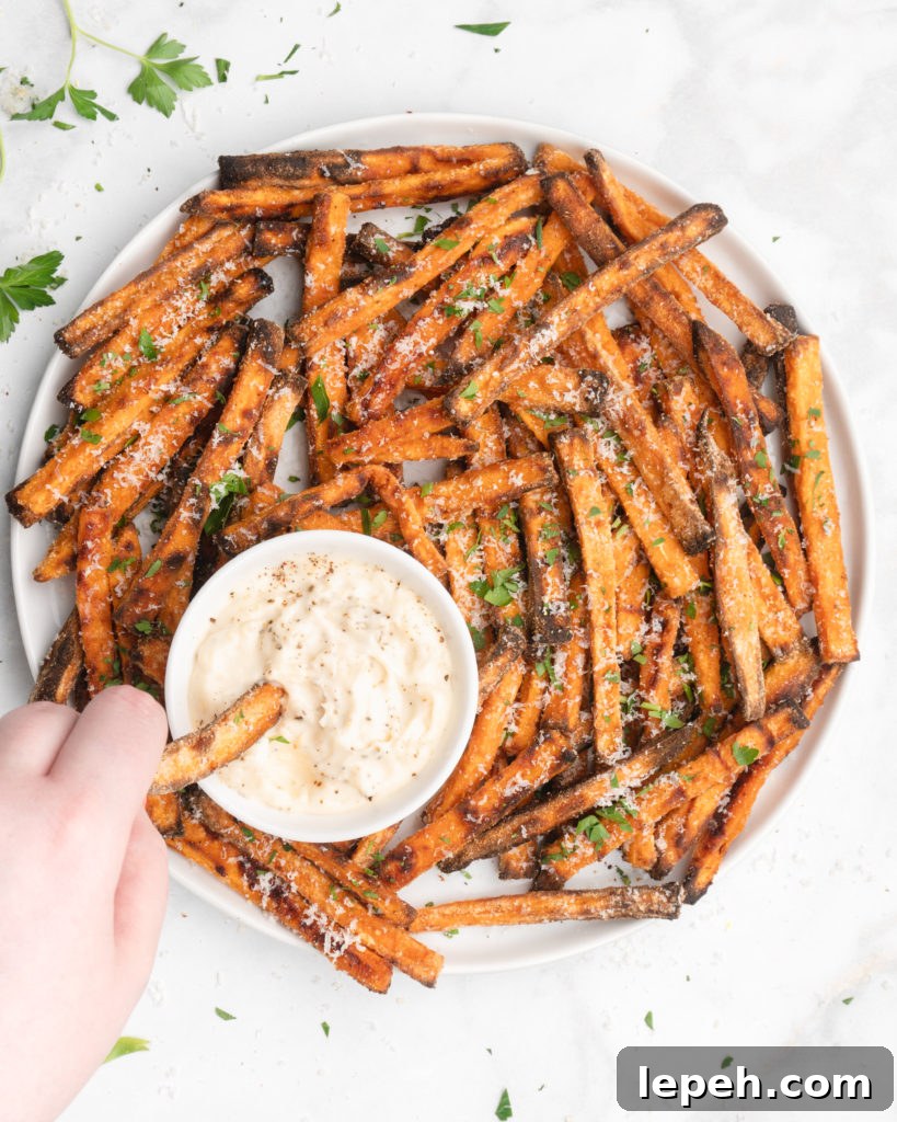 crispy oven baked yam fries are topped with finely shredded parmesan cheese and served with a flavorful homemade truffle lemon aioli